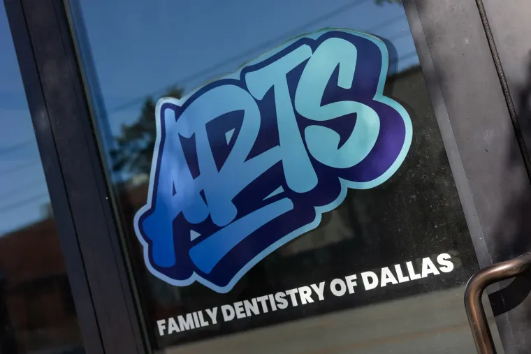 The Arts graffiti logo painted across the storefront glass, reading Family Dentistry of Dallas