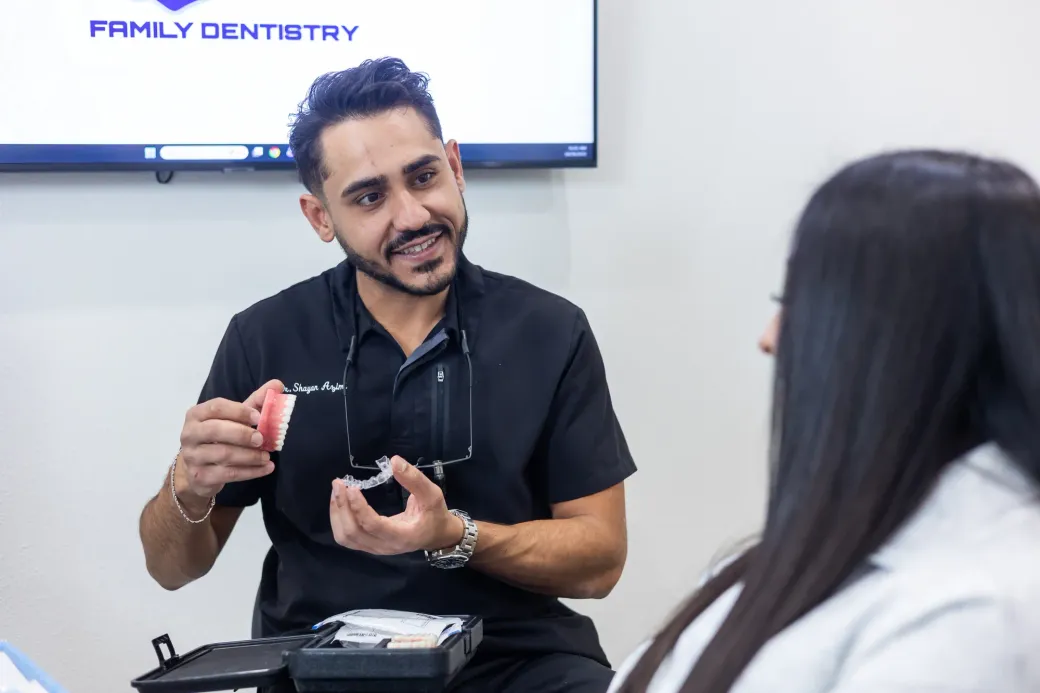 Dr. Shayan Azimi holding a clear aligner case and explaining treatment to a patient