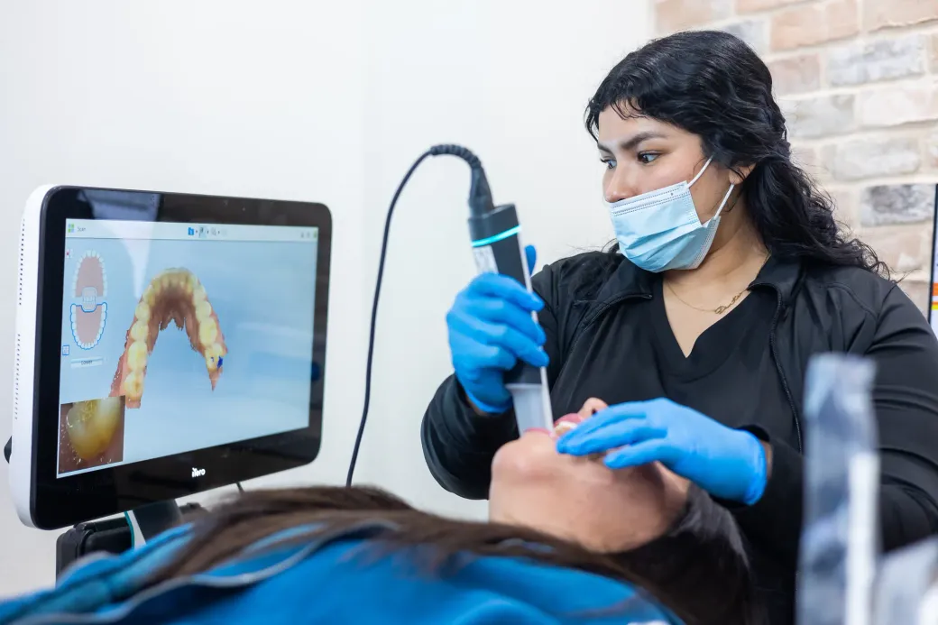 A hygienist using an intraoral camera during a smile assessment