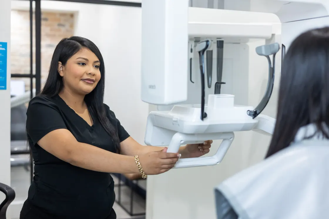 A team member at Arts Family Dentistry positioning the panoramic x-ray scanner for a patient
