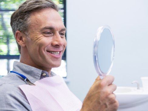 Man looking at smile in mirror