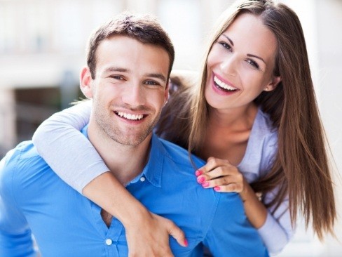 Man and woman enjoying the benefits of getting a dental crown