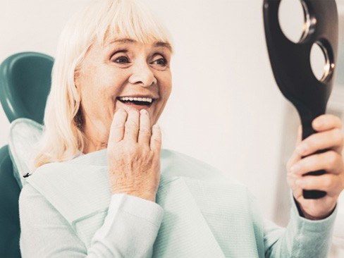 A woman enjoying her dentures in Dallas