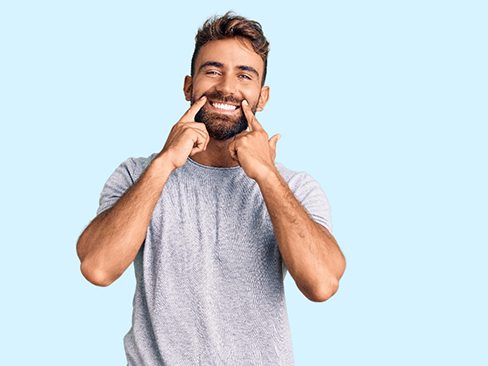 Handsome man pointing at his smile