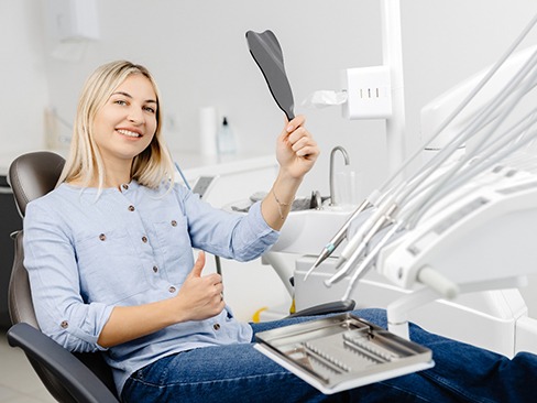 Cosmetic dentistry patient making thumbs up gesture