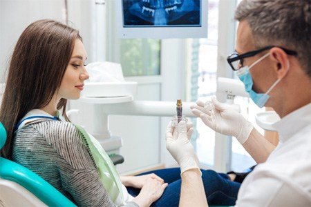 a dentist discussing the cost of dental implants in Dallas