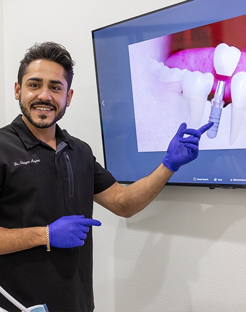 Man and woman with healthy smiles after dental implant tooth replacement