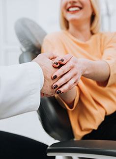 Dentist shaking hands with dental team member