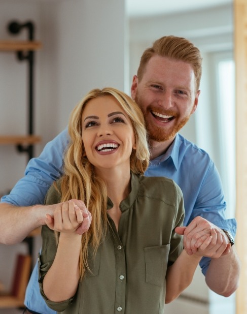 Man and woman with straight smiles thanks to Invisalign