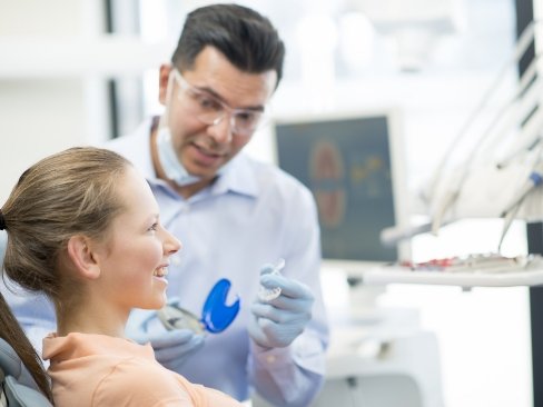 Woman talking to dentist about Invisalign