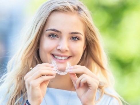 Woman placing an Invisalign aligner tray