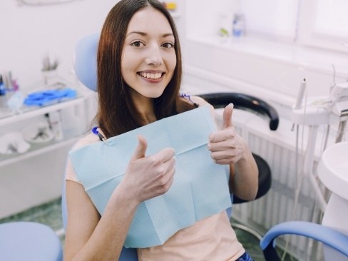 Woman giving two thumbs up after dental checkups and teeth cleanings
