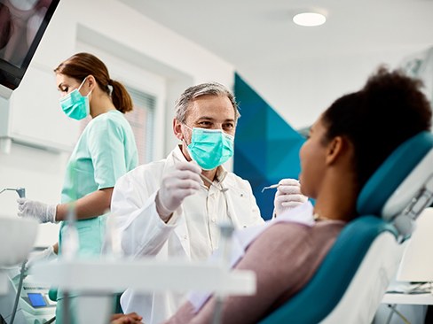 Dentist smiling at patient sitting in treatment chair