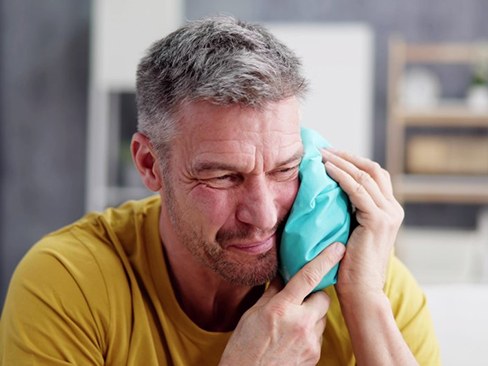 a man holding a cold compress to his jaw
