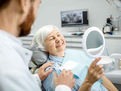 a patient smiling after undergoing dental implant salvage