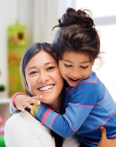 Mother and child smiling together after dental services in Dallas Texas