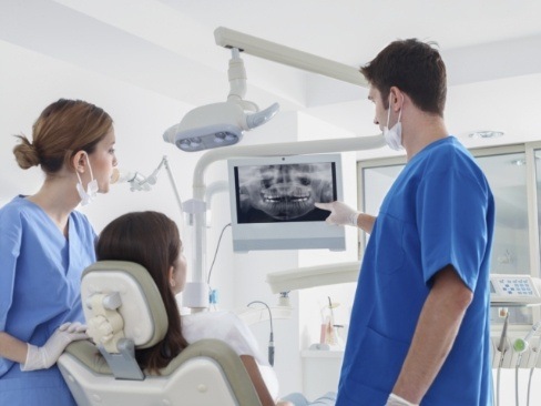 Dentist and patient looking at digital dental x-rays
