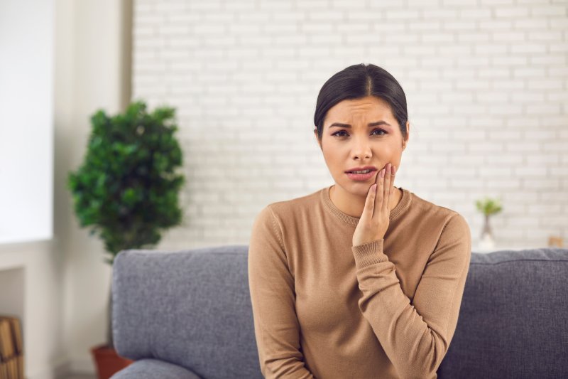 Patient holding their cheek due to facial swelling